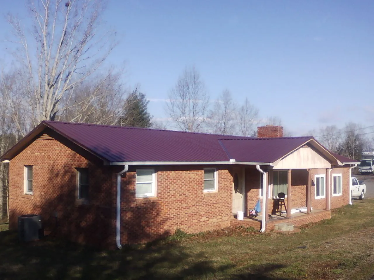 Burgundy metal roof on a brick ranch home with a new addition in Holmdel