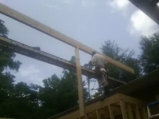 Carpenter setting a ridge beam over a new addition frame — Ice Dam Removal by Roofing Brothers in Holmdel