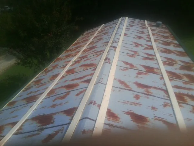 Rusted metal roof panels with new wood purlins before replacement — Storm Damage Roof Repair in Holmdel by Roofing Brothers