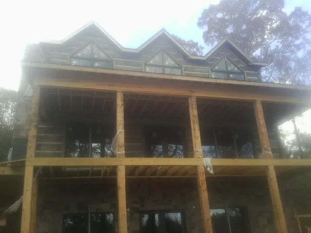 Dormers and porch framing on a large log home under construction — Roof Coating work by our crew in Holmdel