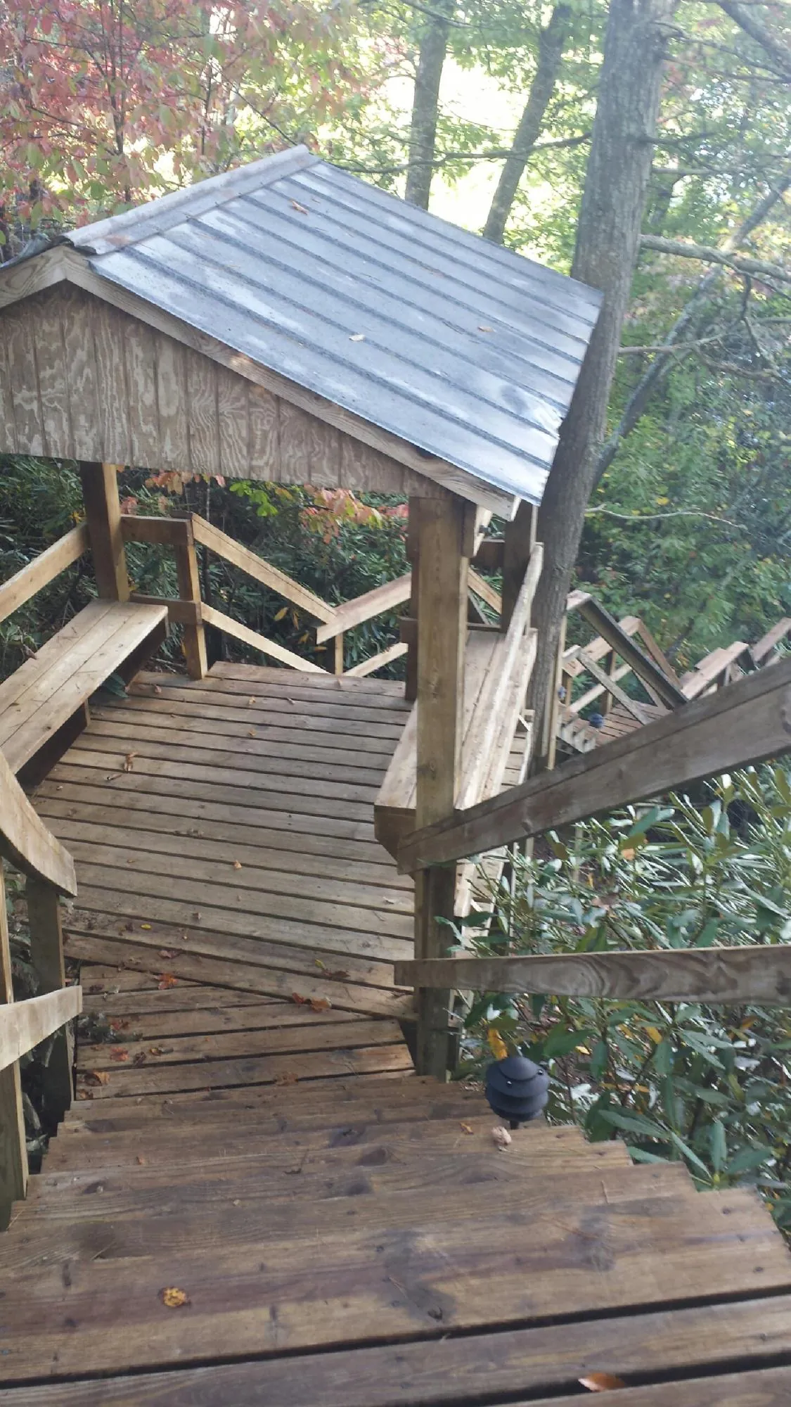 Metal roofed shelter over wooden steps on a wooded walkway — Skylight Repair & Installation work by our crew in Holmdel