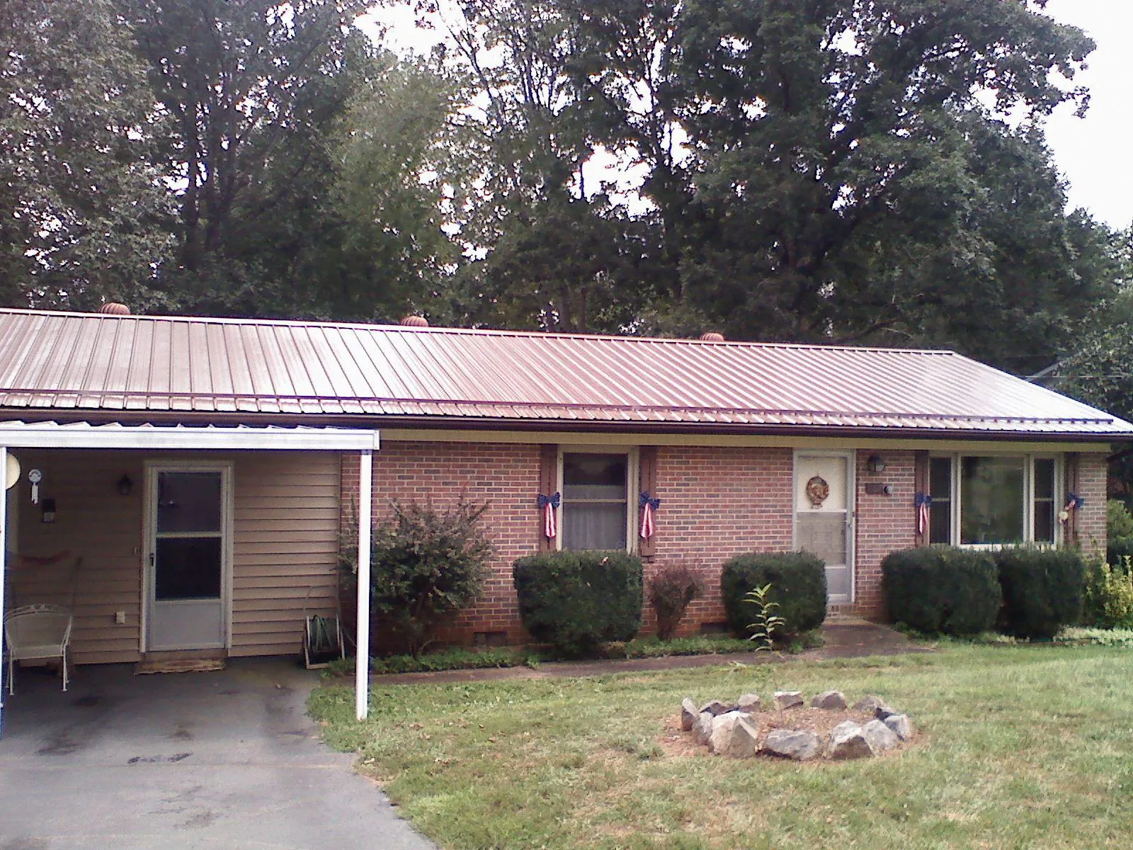 Bronze metal roof and carport on a brick ranch home — Roof Repair work by our crew in Holmdel